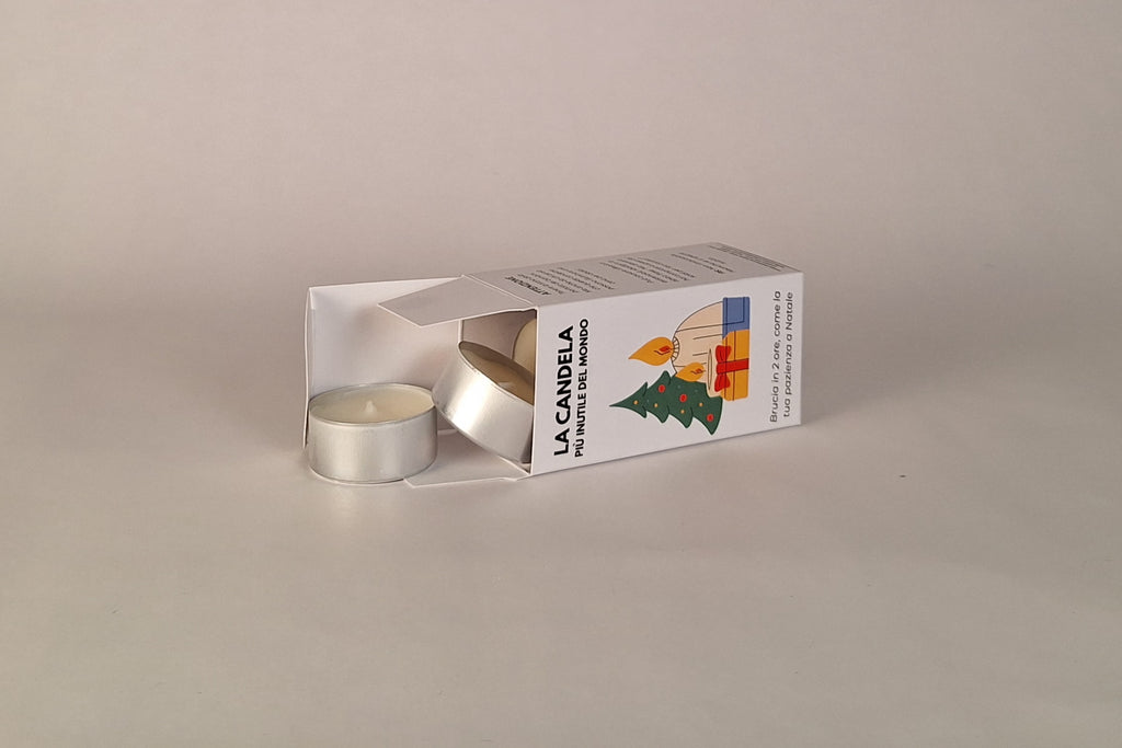 Candeline bianche in alluminio accanto alla confezione natalizia divertente ForseNO.
